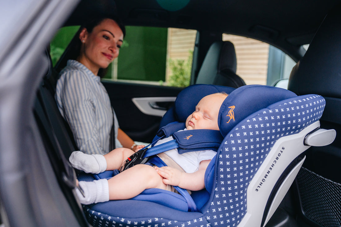 Mamma con bambino neonato su seggiolino auto dalla nascita Storchenmuhle isize